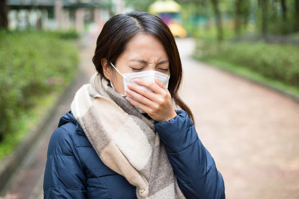 Азиатская молодая женщина больна и носит маску
 - Фото, изображение