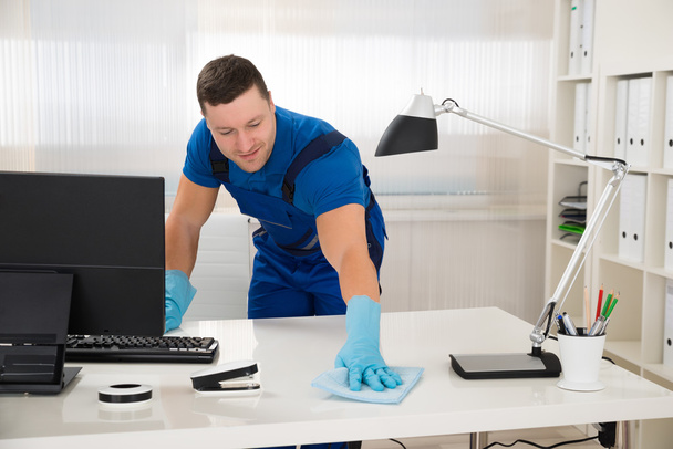 Worker Cleaning Desk With Sponge - Foto, Imagen