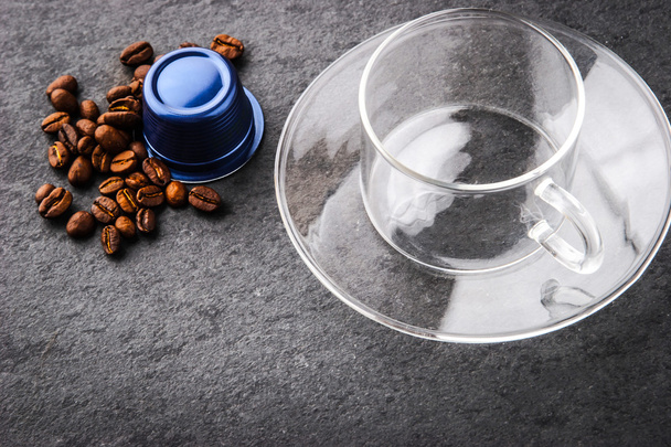 Copa de vidrio con cápsula de café y granos de café
 - Foto, imagen