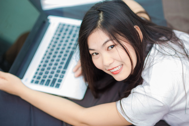 Feliz sonriente asiático mujeres navegar por internet en el ordenador portátil
  - Foto, imagen