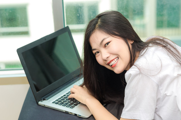 Счастливые улыбающиеся азиатские женщины просматривают интернет на ноутбуке
  - Фото, изображение