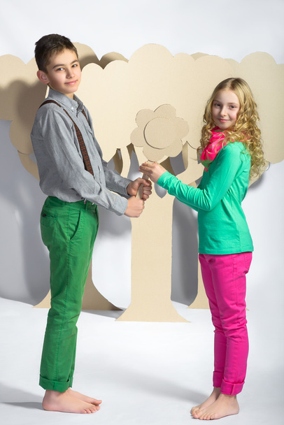 Love concept. Couple of kids. boy gives a girl cardboard flowers - Photo, Image