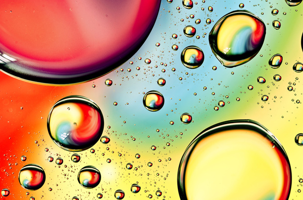 Close-up on water drops background on rainbow colors surface. Water droplets on glass with reflections in them - Zdjęcie, obraz