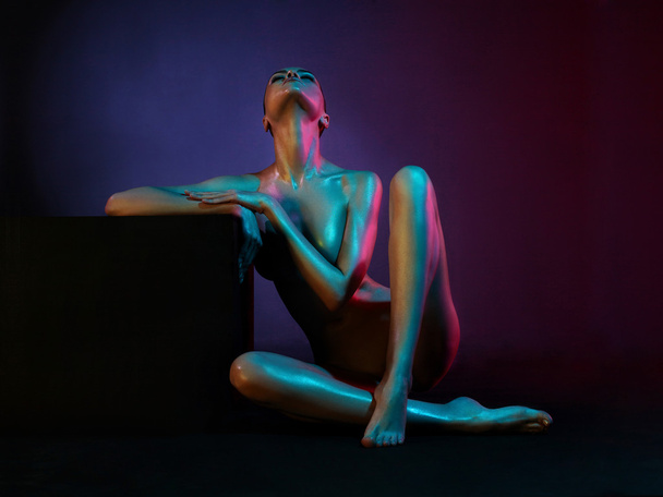 Elegant nude model in the light colored spotlights - Photo, Image