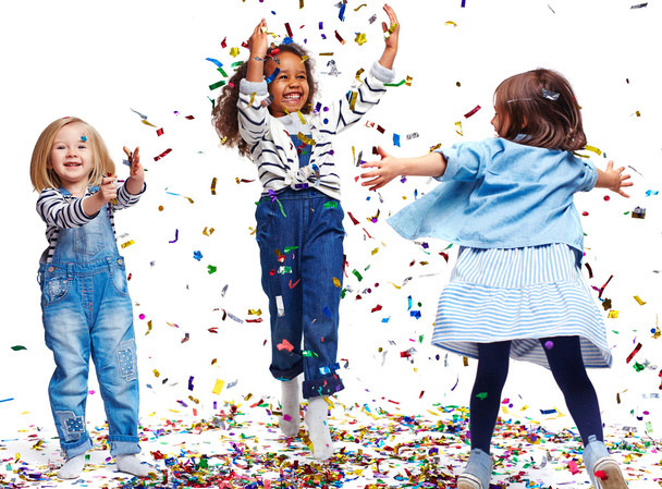 Little happy girls playing with confetti - Фото, изображение