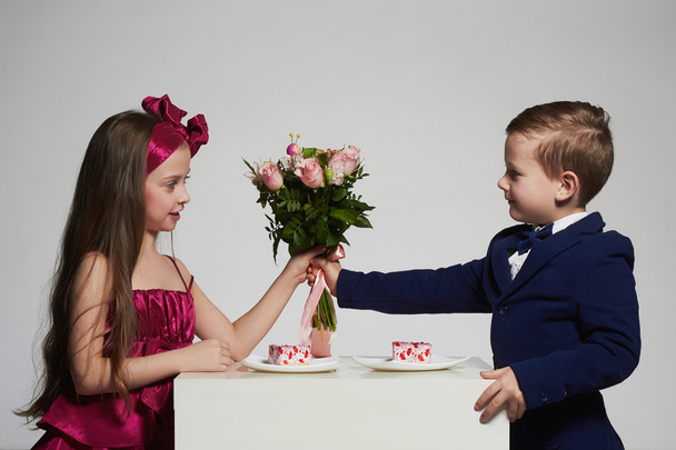 хлопчик дарує дівчині квіти.маленька красива пара.kids
 - Фото, зображення