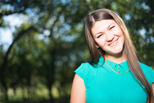 Jovem mulher de negócios feliz bonita em camisa verde ao ar livre
 - Foto, Imagem