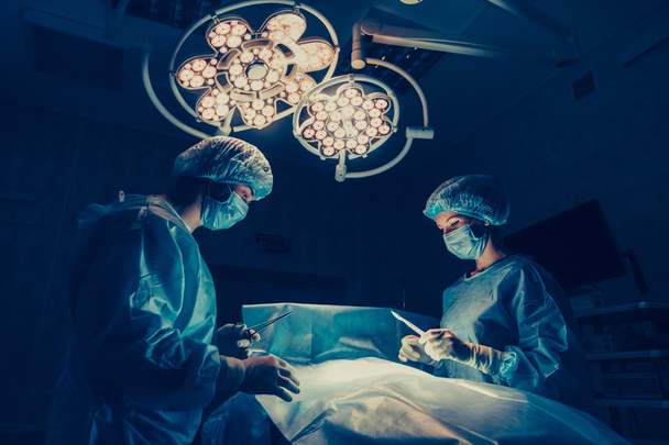 Cerrahlar ekibi cerrahi ameliyathane hastada izleme ile çalışıyor. Göğüs büyütme - Fotoğraf, Görsel