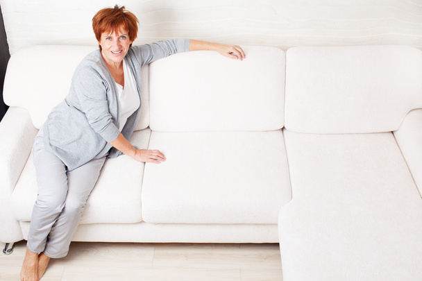 Happy mature woman on sofa - Valokuva, kuva