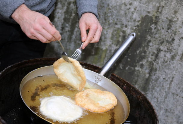 mains pendant la préparation des beignets dans l'huile chaude
 - Photo, image