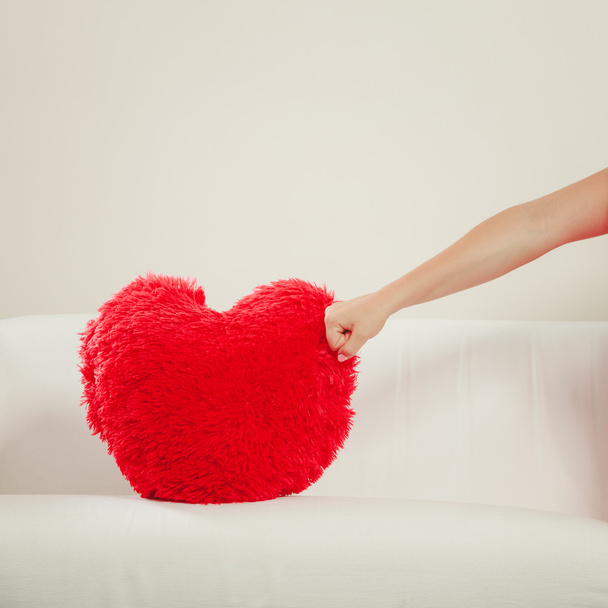 hand punching  red heart pillow. - Valokuva, kuva