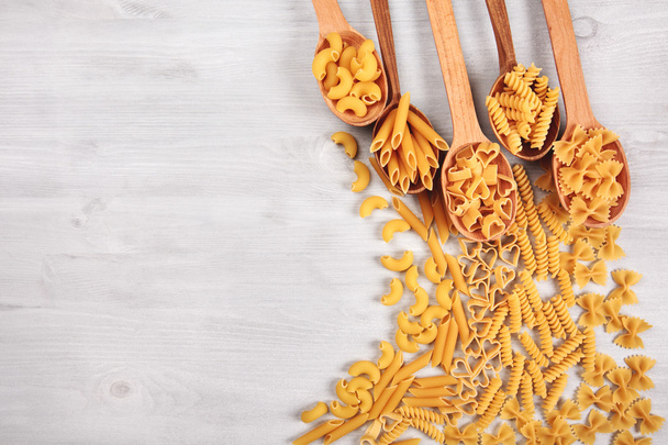 Different types of pasta lying in wooden spoons - Foto, immagini