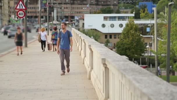 Male with backpack walking across the bridge - Video, Çekim