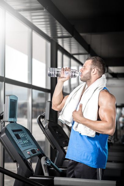 Young man drinking water in gym - Fotoğraf, Görsel