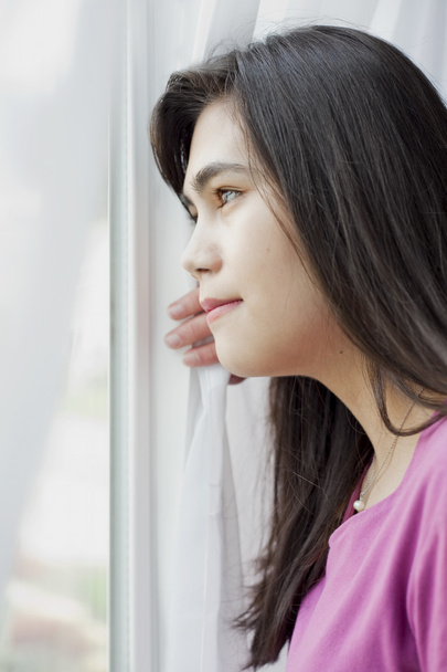 Side profile of teen girl looking out window - Foto, Imagem