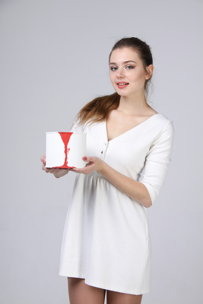 girl in white dress holding paint can - Фото, изображение