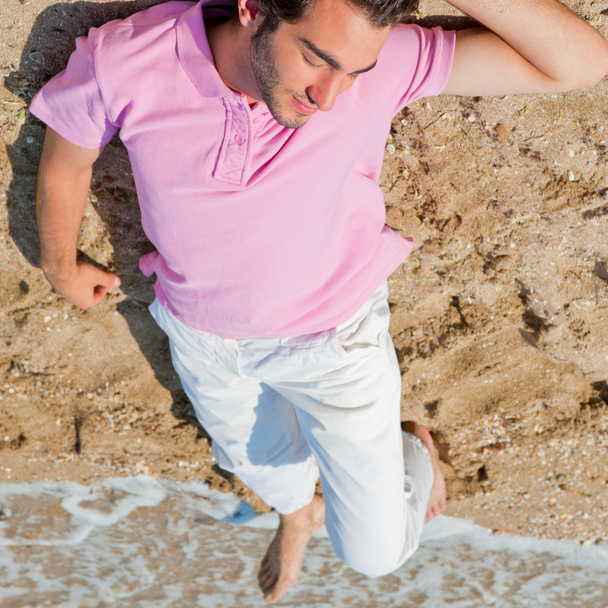 Portrait of attractive and happy man on the beach relaxing and d - 写真・画像