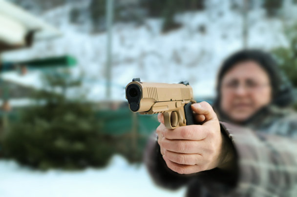 Γυναίκα γυρίσματα εξωτερική με ένα πυροβόλο όπλο, επιλεκτική εστίαση - Φωτογραφία, εικόνα