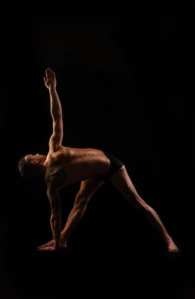 Practice yoga and gymnastics on a black background - Foto, afbeelding