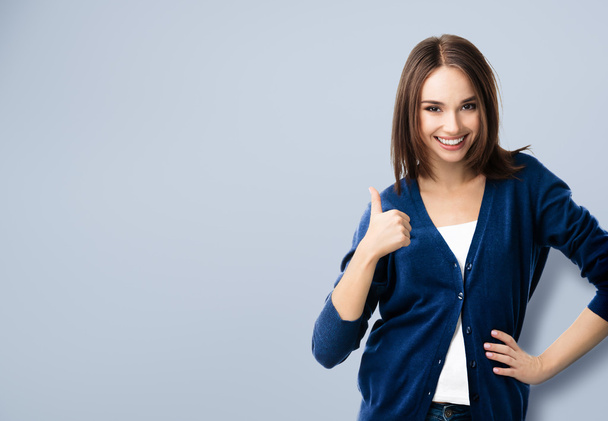 young woman showing thumbs up gesture, with copyspace - Foto, afbeelding