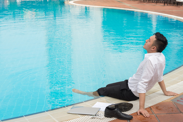 Liikemies rentoutumassa uima-altaalla
 - Valokuva, kuva