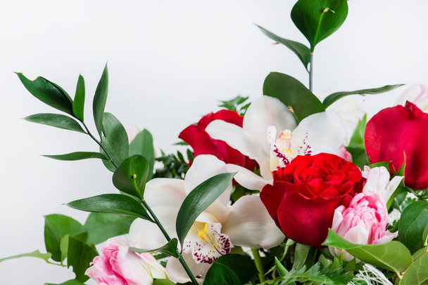 closeup of orchid and red roses in a bouquet of flowers - Foto, afbeelding