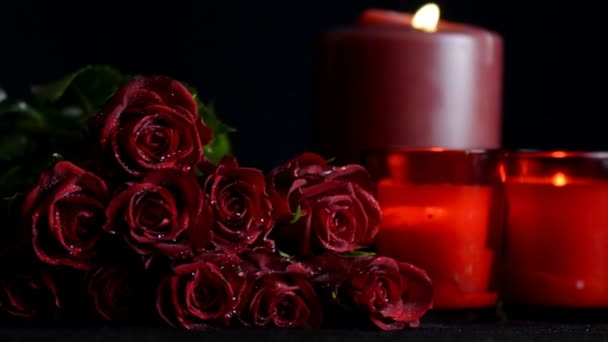 Saint Valentin roses rouges romantiques, zoom avant, avec des bougies allumées sur fond noir
. - Séquence, vidéo