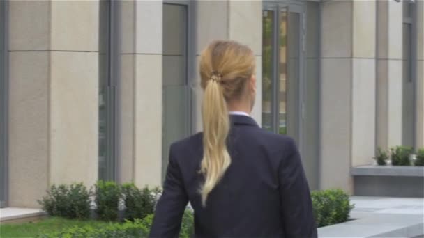 elegant blonde business woman with tablet computer goes around office building. slow motion - Footage, Video
