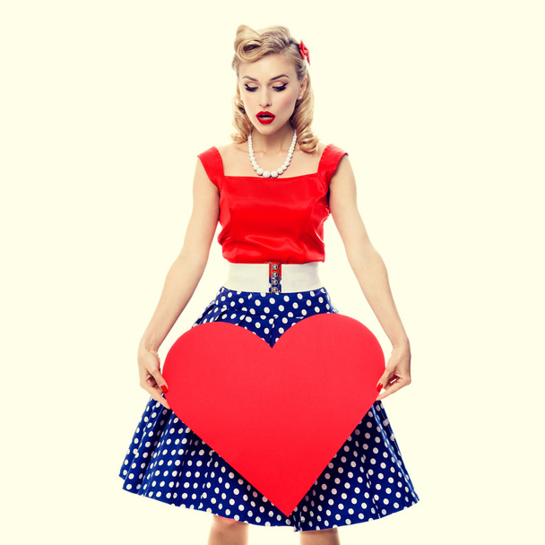 smiling woman holding heart symbol, dressed in pin-up style - Photo, Image