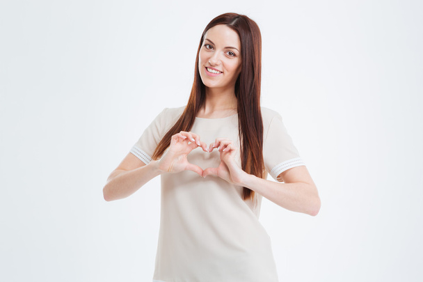 Beautiful smiling young woman showing heart with fingers  - Photo, Image