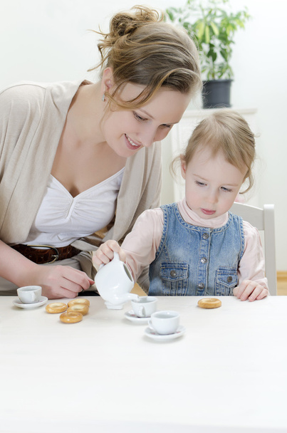 Mom and daughter having tea with bagels - Photo, Image
