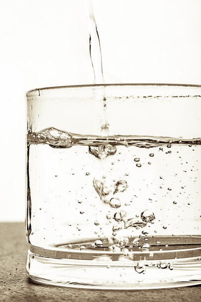 Glas met water op de witte achtergrond - Foto, afbeelding