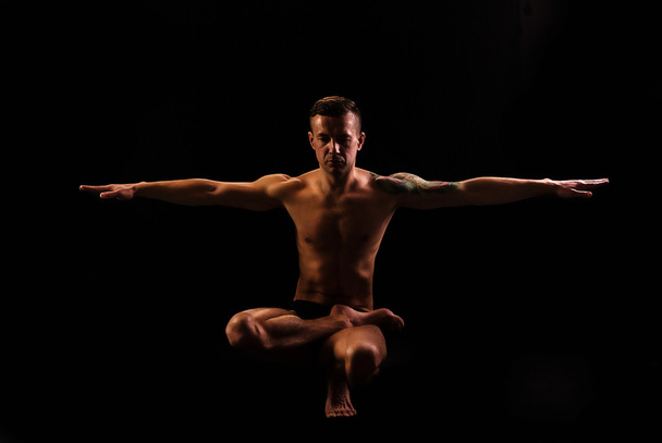 молодой сильный человек, занимающийся йогой и гимнастикой, равновесие
 - Фото, изображение