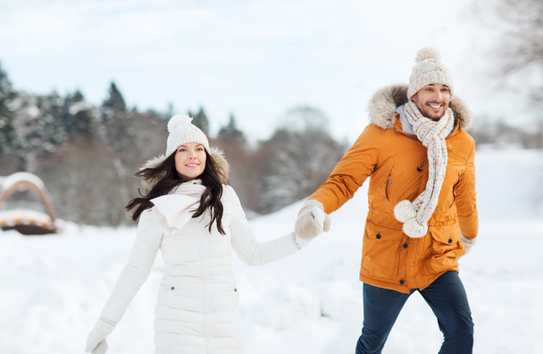 happy couple walking over winter background - Zdjęcie, obraz