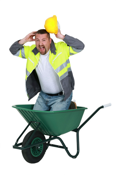 Builder screaming whilst knelt in wheelbarrow - Fotoğraf, Görsel