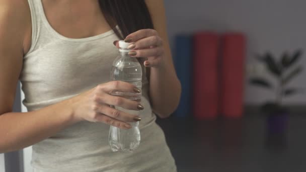 Frau in Turnhalle trinkt Wasser - Filmmaterial, Video