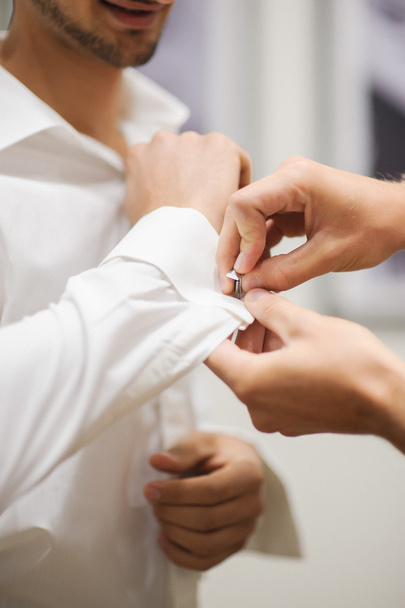 A groom fastening a cuff-lin - Photo, Image