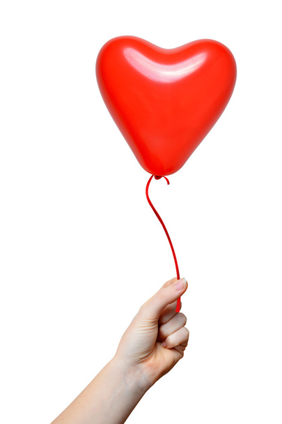 Mano sosteniendo un globo rojo del corazón
 - Foto, imagen
