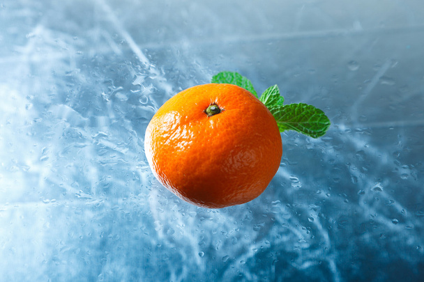 Мандарин на ледяном фоне крупным планом
 - Фото, изображение