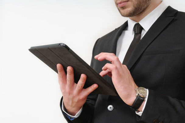 business man body side in black suit holding his tablet on white - Fotó, kép