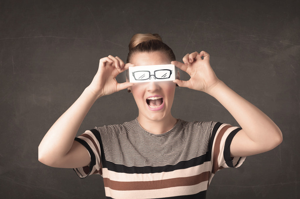 Fille heureuse regardant avec des lunettes en papier dessinées à la main  - Photo, image