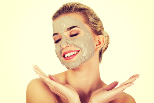 Young happy woman with facial mask. - Φωτογραφία, εικόνα