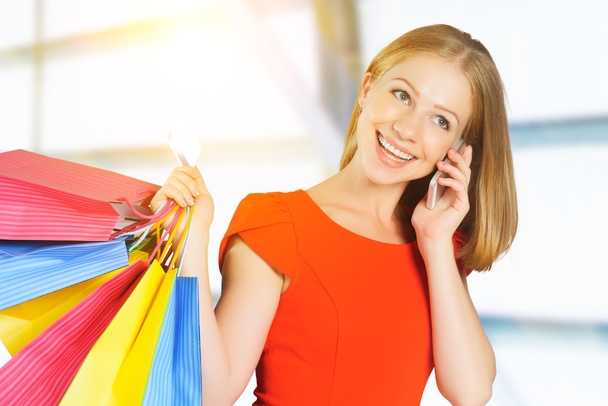 happy woman with  bags on shopping and kredit card talking on ph - Photo, Image