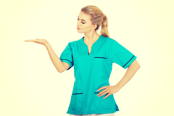 Smiling woman doctor or nurse pointing something - 写真・画像
