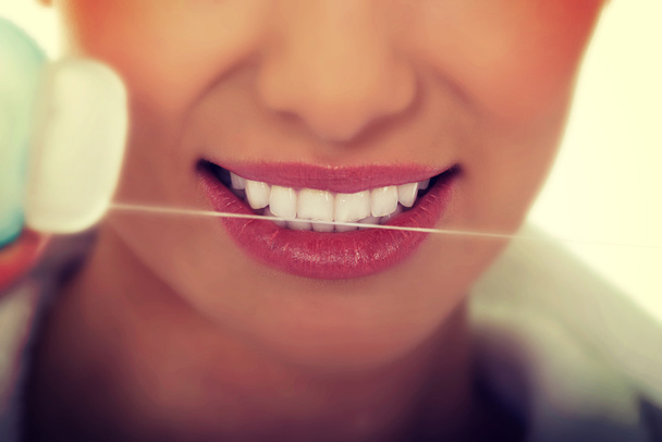 Γυναίκα που χρησιμοποιεί οδοντικό νήμα. - Φωτογραφία, εικόνα