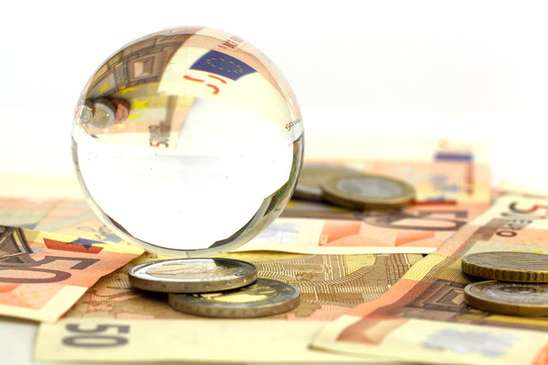 Dinero euro con una bola de vidrio
 - Foto, imagen