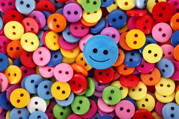 Coloridos botones de pila multicolor solo uno está sonriendo
 - Foto, imagen