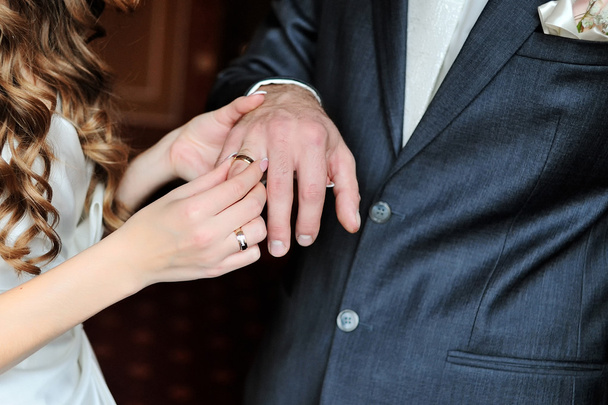 花嫁が結婚式の日に新郎の指に結婚指輪を置く - 写真・画像