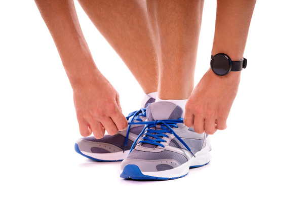 Hands with smartwatch tying sneakers - Foto, immagini