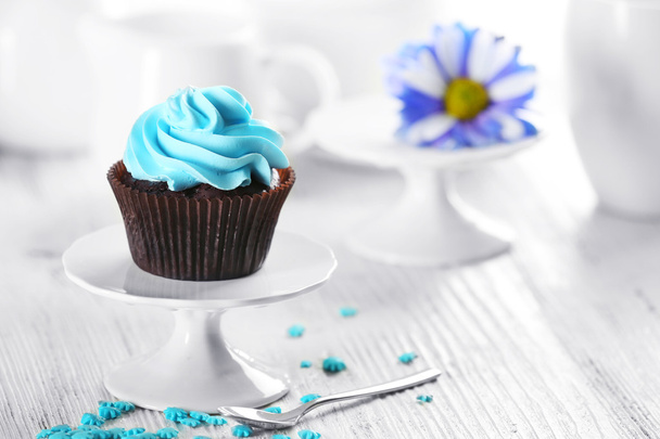 Delicious chocolate cupcake with blue cream on served table, close up - Foto, imagen